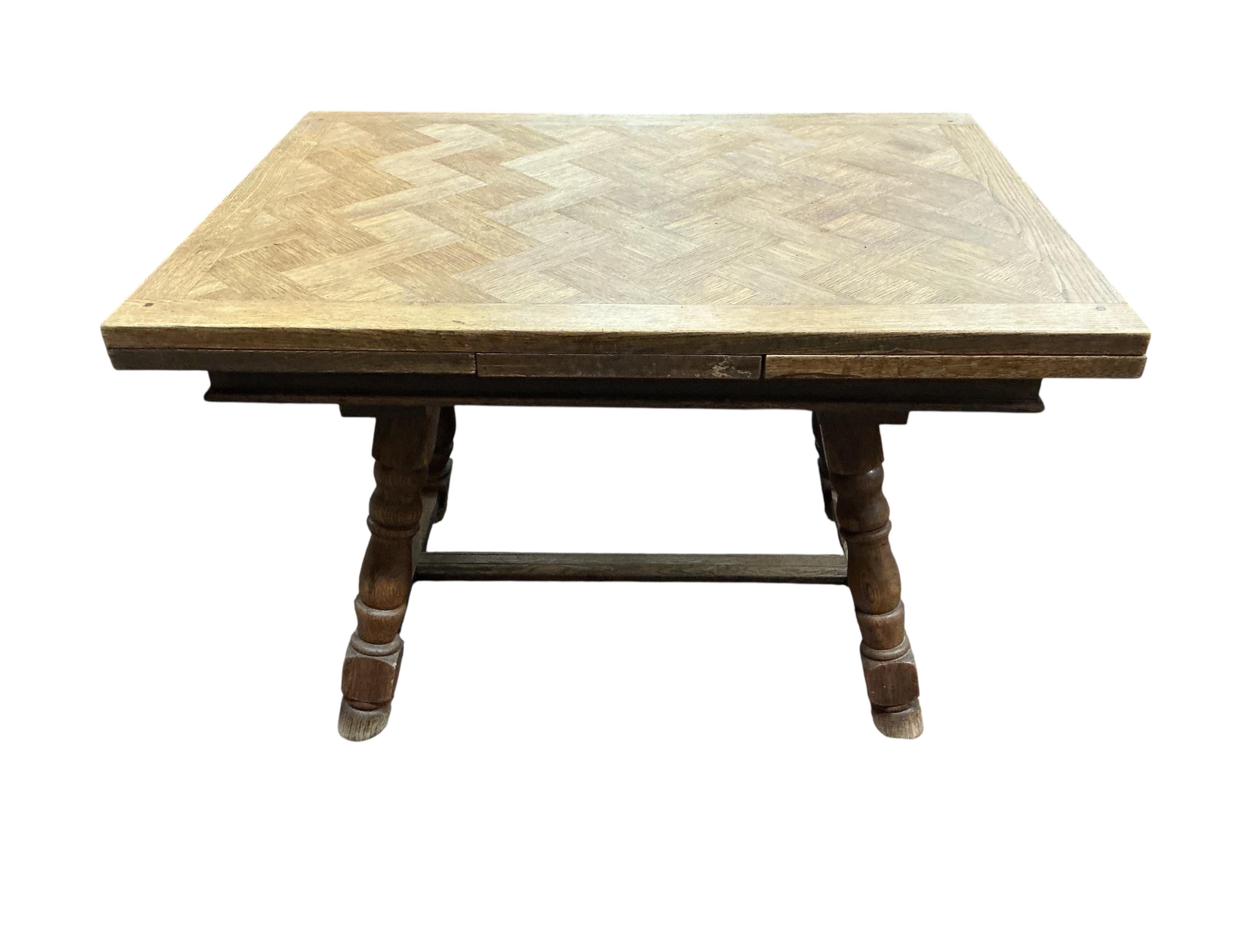 A small late 19th / early 20th century French parquetry oak draw leaf dining table, width 186cm extended, depth 79cm, height 74cm